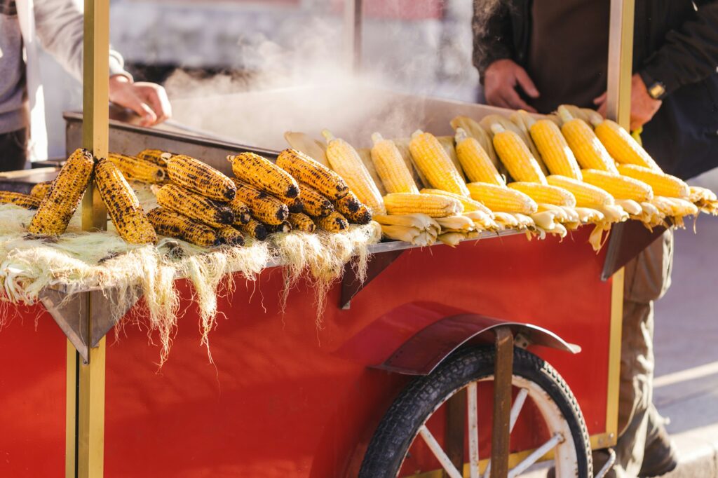 Preparing hot grilled corn outdoors at summer. Asian street food