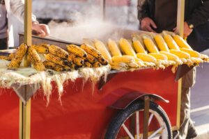 Preparing hot grilled corn outdoors at summer. Asian street food