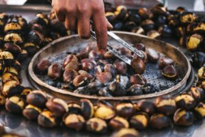 Man preparing roasted chestnuts, cooking outdoors. Street food in Istanbul